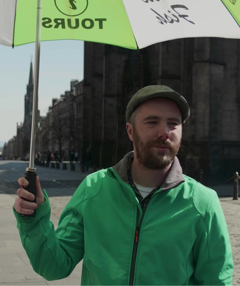 Free tour guide with an umbrella waiting for travellers to check-in